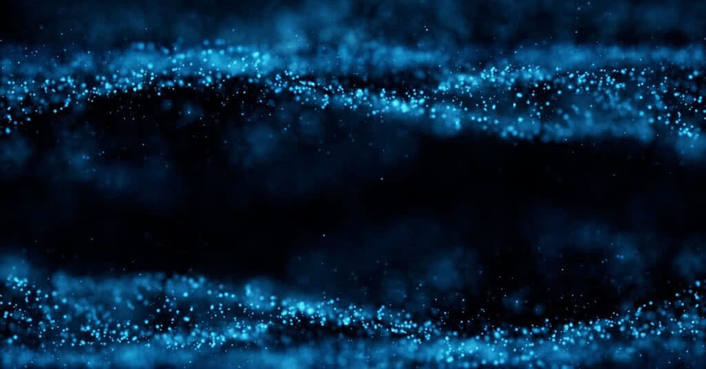 Imagem de partículas abstratas em fundo escuro, relacionada ao artigo sobre embolização de má formação venosa. Conceito gráfico e de movimento.