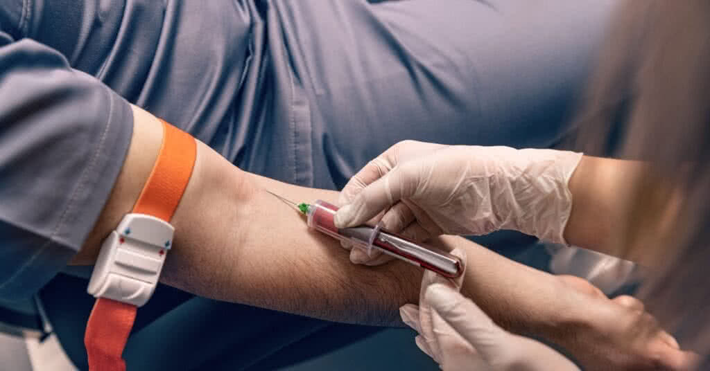 Imagem ilustrativa para o artigo sobre flebite: Técnico de laboratório coletando sangue para análise de flebite.